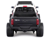 Rear view of the white 2023 Toyota Tacoma TRD Pro off-road pickup with black tailgate and roof rack, Maisto 1:27.