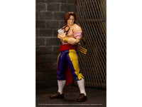 Vega action figure standing in front of a brick and chain-link display backdrop, Jada 35172