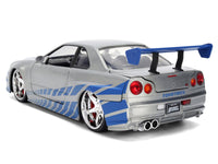 Rear three-quarter view of silver and blue brush-finish Skyline R34 with circular taillights and blue wing, Jada 36818