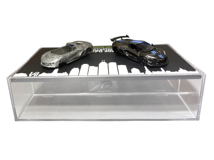 GreenLight 1:64 2025 Corvette C8 ZR1 black with blue details beside its raw casting on the display case, item 51683A.