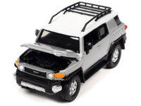 Johnny Lightning 2007 Toyota FJ Cruiser in Titanium Silver with white roof and roof rack.