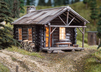 Woodland Scenics BR4961 Cozy Cabin N scale built-up building, front view in a layout scene; surrounding scenery not included.