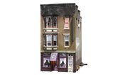 Woodland Scenics BR5051 Betty's Burning Building HO scale Built-&-Ready model, front view with scorched upper floor and purple shop awning.