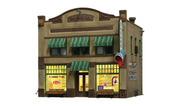 Woodland Scenics BR5053 Dugan's Paint Store HO scale Built-&-Ready building, front view with green awnings and illuminated shop windows.