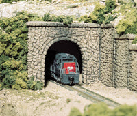 Woodland Scenics C1155 N scale random stone single-track tunnel portals, painted portal in a railway layout; locomotive, track, retaining walls and scenery are separate.
