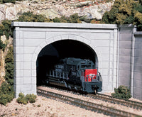 Woodland Scenics C1156 concrete double-track tunnel portal painted in a railway layout; locomotive, track, retaining walls and scenery are separate.