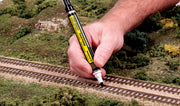 Woodland Scenics TT4582 Weathered Tie Track Painter, application example on model railway ties; track and scenery are not included.