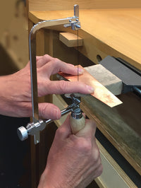 Zona 35-750 adjustable jeweler's saw demonstrated cutting sheet metal at a workbench.