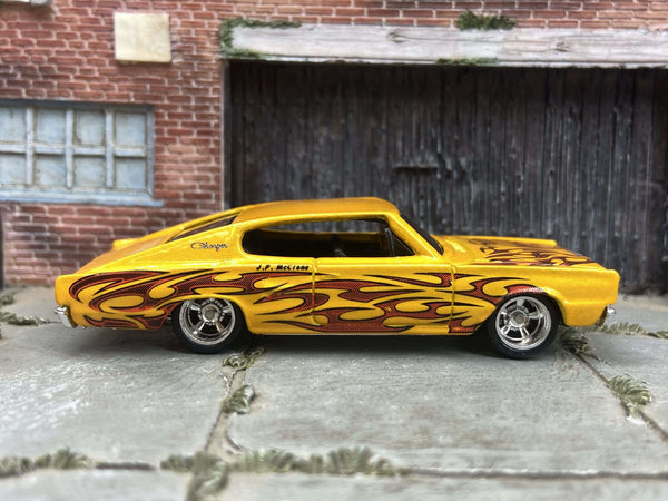 Yellow 1967 Dodge Charger custom Hot Wheels with flame graphics, view 1