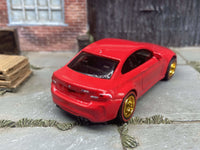 Side view of red BMW M2 custom Hot Wheels with gold 5-spoke wheels