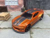 Side view of orange-and-black Camaro COPO custom Hot Wheels with black wheels