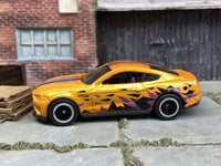 Rear three-quarter view of orange Mustang GT custom Hot Wheels with rubber tires