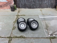 Four 12mm silver AR-style wheels with black rubber tires, view 1