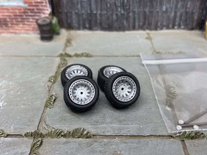 Four 12mm silver AR-style wheels with black rubber tires, view 1