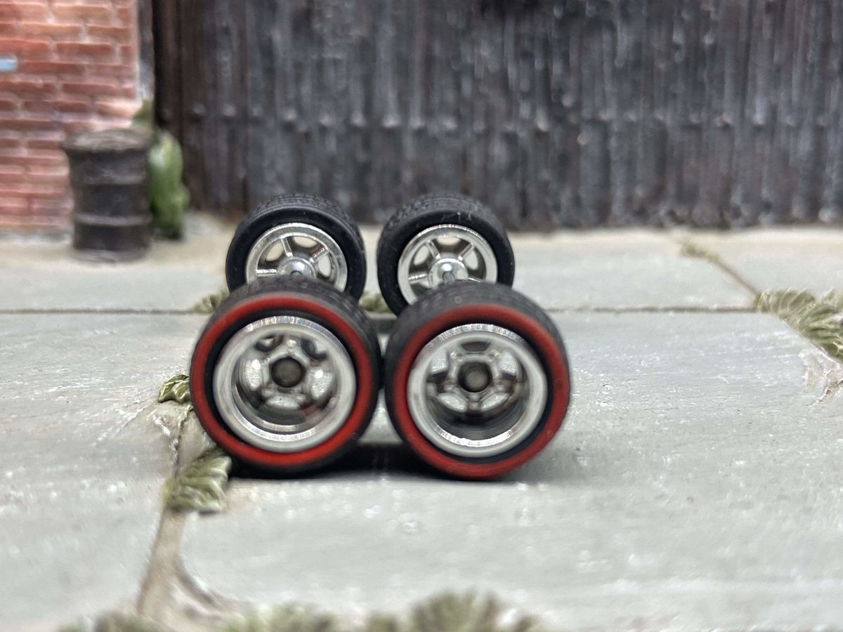 Front view of four chrome five-spoke deep-dish wheels with red-line rubber tires