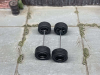 Overhead view of black deep-dish wheels on two axle rods, showing tire tread and rear hubs