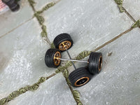 Close view of black-and-gold 5-spoke wheels with rubber tires