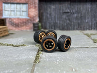 Four black-and-gold 5-spoke wheels with fitted black rubber tires