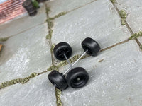 Overhead view of black wheels showing front faces, rear hubs, and two crossing axle rods