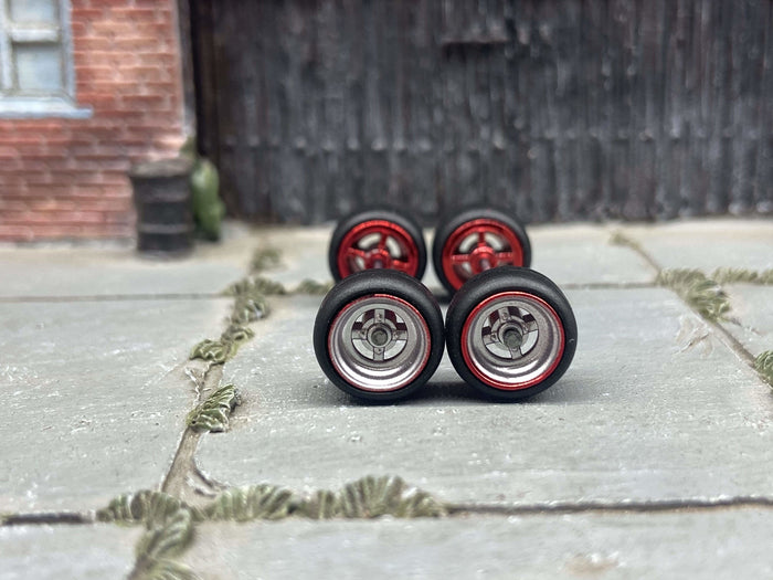 Front view of four 10mm chrome and red 4-spoke wheels with black rubber tires