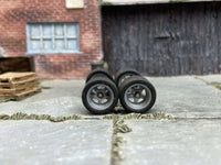 Front view of four 12mm gray racing 5-spoke wheels with black rubber tires