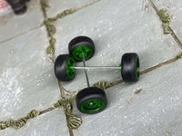 Overhead view of green wheels showing front faces, rear hubs, and two crossing axle rods