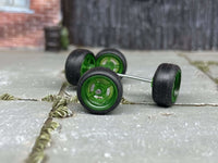 Close-up of four green four-spoke wheels with black tires