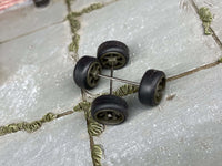 Overhead view of green/drab wheels showing front faces, rear hubs, and crossing axle rods