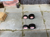 Alternate view of four pink 4-spoke wheels with black rubber tires