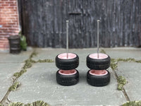 Pink wheels stacked in pairs to show tire profiles and upright axle rods