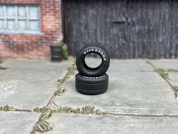 Two 13mm Firestone-lettered drag slick rubber tires, view 1