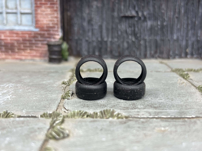 Four 10mm road-race slick rubber tires without wheels, view 1