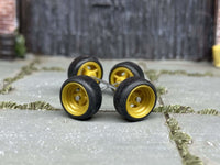Four mustard-yellow 4-spoke wheels with fitted black rubber tires