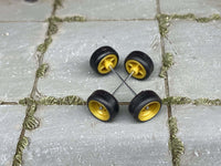 Close view of mustard-yellow 4-spoke wheels with rubber tires