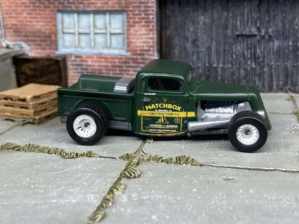 Custom Matchbox 1935 Ford pickup hot rod in satin green with chrome mag wheels and rubber tires, side profile showing the door graphics