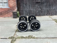 Front view of four 10mm black wheels with whitewall rubber tires