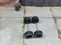 Overhead view of black wheels with whitewall rubber tires positioned on axle rods