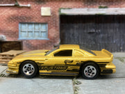 Loose Hot Wheels Ford Mustang Cobra Race Car Dressed in Gold and Black Mustang Livery