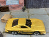 Loose Hot Wheels Ford Mustang Cobra Race Car Dressed in Gold and Black Mustang Livery